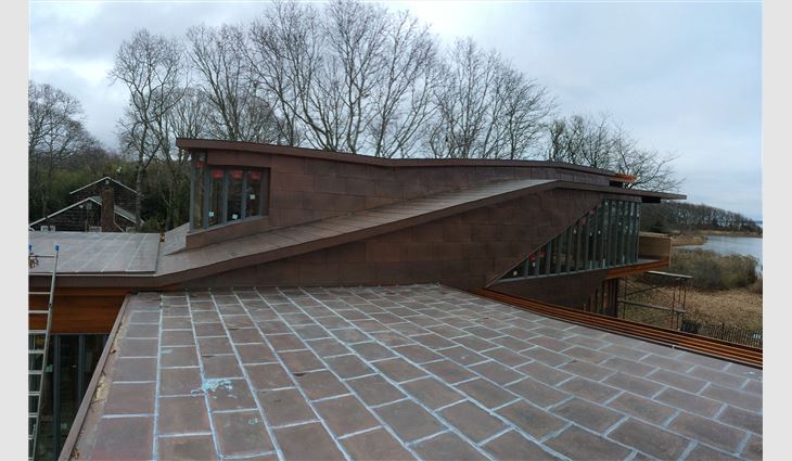 TRM Enterprises craftsmen soldered copper sheet panels on low-slope roof areas.