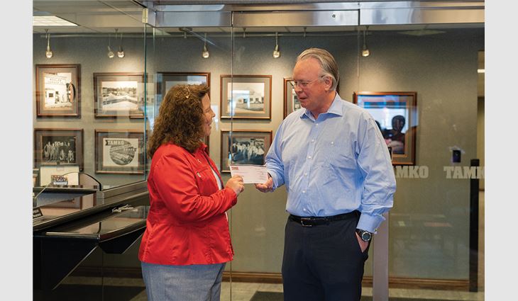 David Humphreys, president and CEO of TAMKO Building Products, presents a $100,000 check to Stacy Burks, executive director of the American Red Cross of Southern Missouri, for disaster relief efforts.